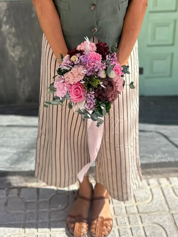 Déjate envolver por la dulzura y sofisticación del ramo Claudia, una creación artesanal realizada con flores 100 % preservadas que mantienen su belleza intacta durante años. Este diseño exclusivo destaca por su paleta de tonos rosados, burdeos y lavanda, perfecta para ocasiones especiales o como pieza decorativa atemporal.